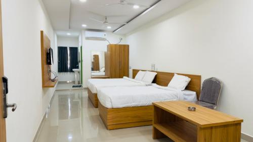 a bedroom with a bed and a table in it at SRI HARSHA AC Luxury rooms in Warangal