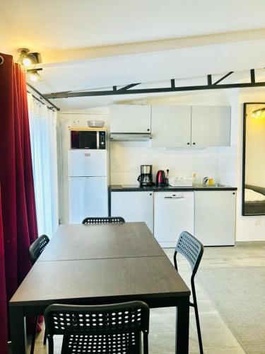 une cuisine avec une table et des chaises dans une pièce dans l'établissement Le Bon Repos - Séjours professionnels et vacances en famille aux portes de Paris, à Garches