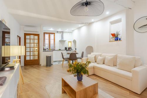 un salon avec un canapé blanc et une table dans l'établissement Cocon charmant et paisible au cœur du Vieux Nice, à Nice