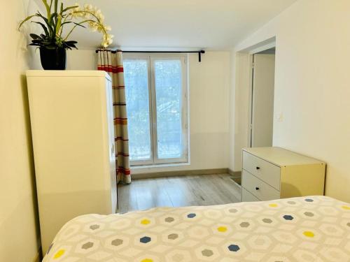ein Schlafzimmer mit einem Bett und einem Fenster in der Unterkunft Le Bon Repos - Séjours professionnels et vacances en famille aux portes de Paris in Garches