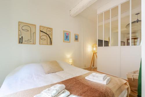 une chambre avec un lit avec deux serviettes dessus dans l'établissement Cocon charmant et paisible au cœur du Vieux Nice, à Nice
