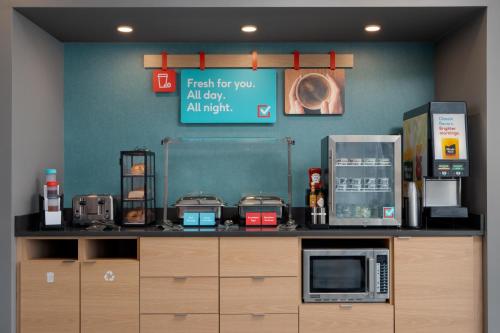 a coffee shop with a counter with a microwave at avid hotel Oak Creek by IHG in Oak Creek