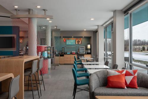 a restaurant with tables and chairs and a cafeteria at avid hotel Oak Creek by IHG in Oak Creek