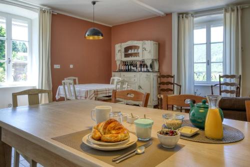 a table with a plate of food on top of it at Les Jardins d'Anna - Chambres d'hôtes in Tapon