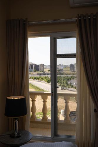 a room with a window with a view of a balcony at Just Move Luxury 1BR APT, Near ISB Int'l AIRPT in Islamabad