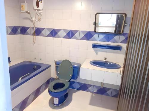 a bathroom with a blue toilet and a bath tub at XX Mitr Inn - Phuket Old Town in Phuket