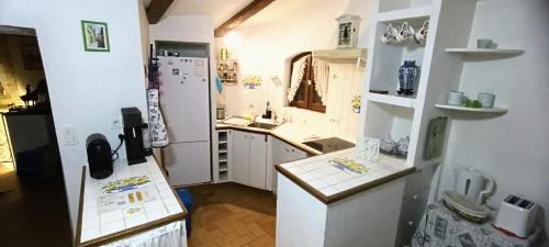 une petite cuisine avec un évier et un réfrigérateur dans l'établissement F3 Vieux Village Roquebrune Cap Martin RCM, à Roquebrune-Cap-Martin