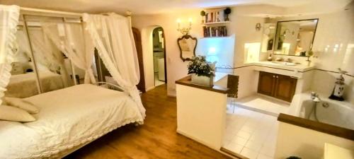 une chambre avec un lit et une salle de bain avec baignoire dans l'établissement F3 Vieux Village Roquebrune Cap Martin RCM, à Roquebrune-Cap-Martin
