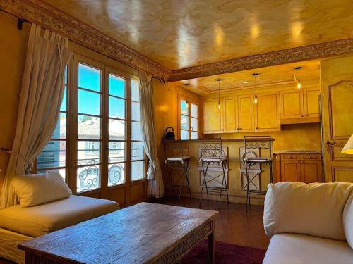 un salon avec une table et une cuisine dans l'établissement Appartement Place des Lices, Saint-Tropez, à Saint-Tropez