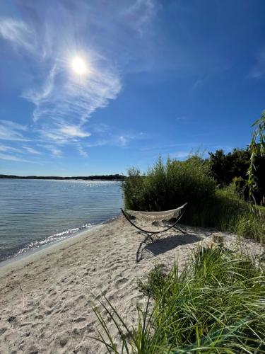 a boat sitting on a sandy beach next to the water at Villa Daries - Ferienwohnung mit eigenem Müritzstrand in Waren