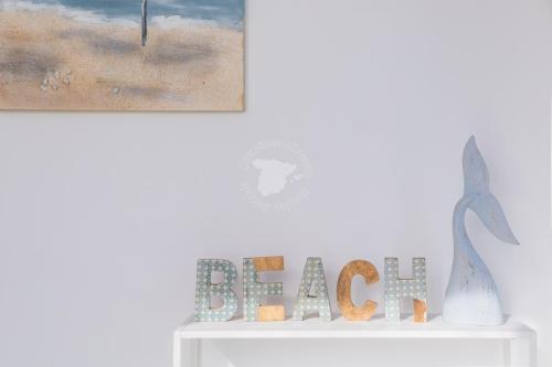 a white shelf with a sign and two paintings at CostaBlancaDreams Calpe Beach 2 6O in Calpe in Calpe