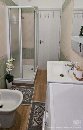 a white bathroom with a sink and a shower at Appartamento Granella in Voghera