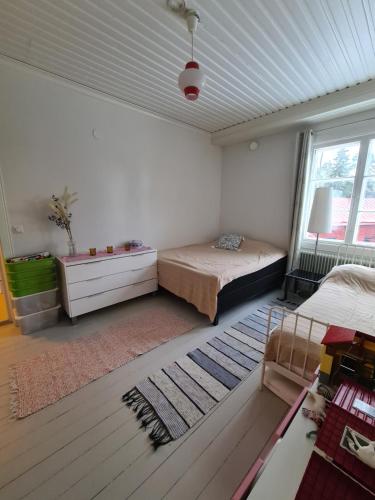 a bedroom with a bed and a window at Ainutlaatuinen huoneisto Vanhassa kyläkoulussa in Purola
