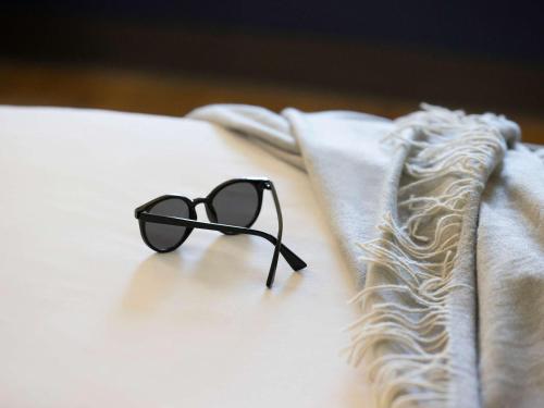 a pair of sunglasses sitting on top of a bed at ibis Budget Brisbane Airport in Brisbane