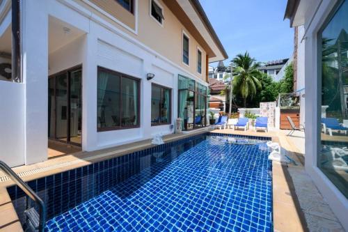 a swimming pool next to a house with a villa at San pool villa in Patong Beach
