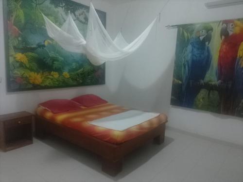a bed in a room with a painting on the wall at Appartement familial spacieux avec climatisation in Ziguinchor