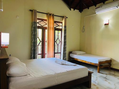 a bedroom with two beds and a window at Lihini Scandic in Seeduwa