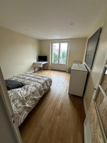 une chambre avec un lit, un bureau et une fenêtre dans l'établissement Appartement place Nevers, à Charleville-Mézières