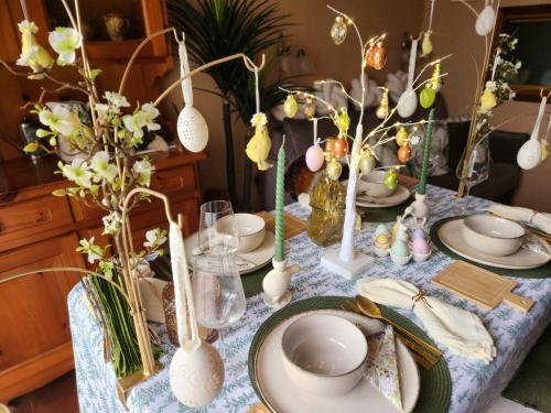 a table with plates and vases with flowers on it at Sophia Apartment Triora in Triora