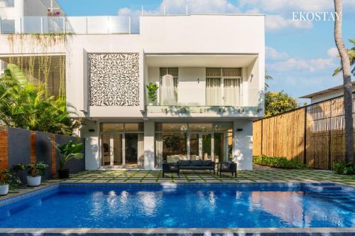 a house with a swimming pool in front of it at EKOSTAY Luxe I Avante Villa in Calangute