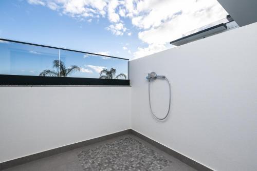 a bathroom with a shower with a large window at Sunset View Apartment in Conceicao de Tavira in Tavira