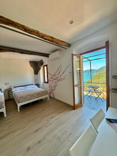 Un dormitorio con una cama y un balcón con vistas. en Belvedere Home Holiday, en Corniglia