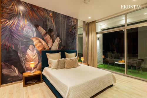 a bedroom with a bed with a large painting on the wall at EKOSTAY Luxe I Avante Villa in Calangute