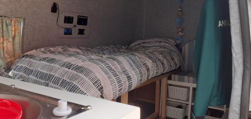 a small bed in a small room with a table at My place in Marlow