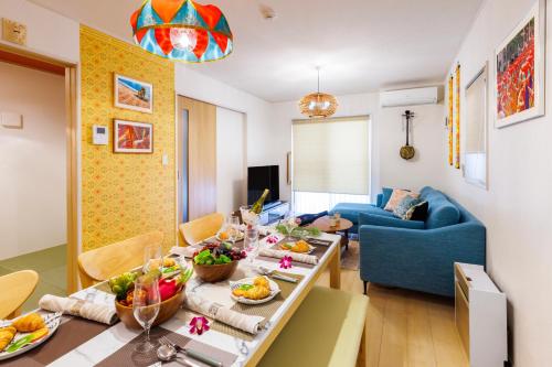 a living room with a table with food on it at 最大12人 那覇空港から車で15分 無料駐車場2台 南部を満喫したい方に1番のおすすめ宿 The Art Ryukyu アート琉球 in Itoman