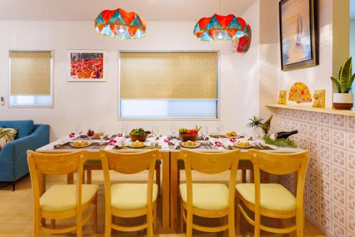 a dining room with a table and chairs at 最大12人 那覇空港から車で15分 無料駐車場2台 南部を満喫したい方に1番のおすすめ宿 The Art Ryukyu アート琉球 in Itoman