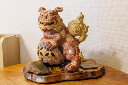 a statue of a cat sitting on top of a table at 最大12人 那覇空港から車で15分 無料駐車場2台 南部を満喫したい方に1番のおすすめ宿 The Art Ryukyu アート琉球 in Itoman