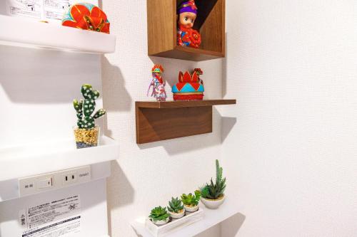 a room with plants on the wall and shelves at 最大12人 那覇空港から車で15分 無料駐車場2台 南部を満喫したい方に1番のおすすめ宿 The Art Ryukyu アート琉球 in Itoman