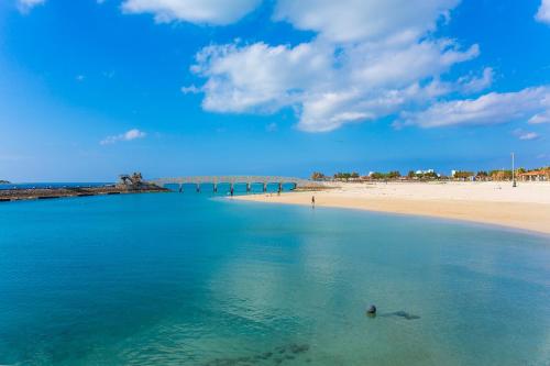 a view of a beach with a bridge in the water at 最大12人 那覇空港から車で15分 無料駐車場2台 南部を満喫したい方に1番のおすすめ宿 The Art Ryukyu アート琉球 in Itoman