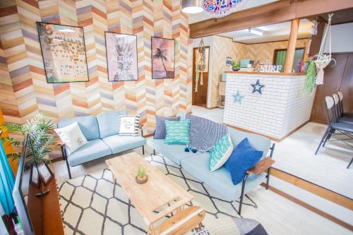 a living room with blue chairs and a table at Hill Atagawa Villent in Higashiizu