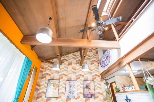 a ceiling fan and paintings on a wall in a room at Hill Atagawa Villent in Higashiizu