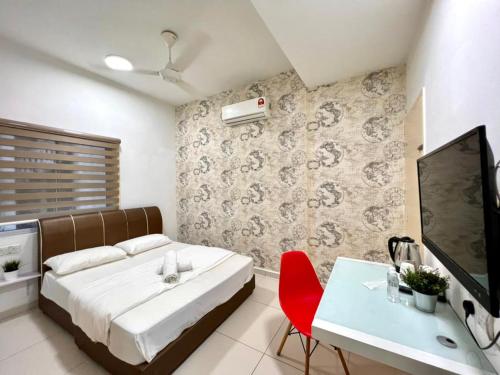 a bedroom with a bed and a table and a tv at Melaka Stay in Malacca