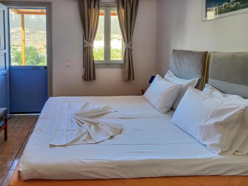 a large white bed in a room with windows at Katerina Studios Mparou in Apollonia