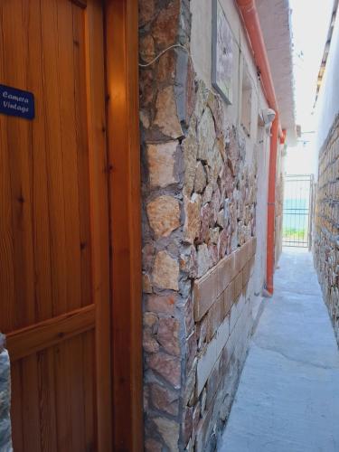 an entrance to a building with a stone wall and a wooden door at LA TERRAZZA SUL MARE camera vicino aereoporto&mare SICILIAN VINTAGE STYLE SEASIDE ROOM in Cinisi