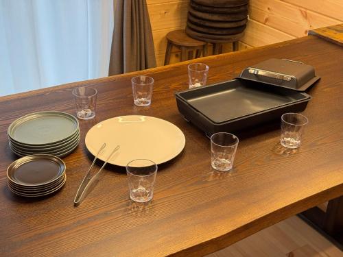 a table with plates and glasses on a table at P's Wood 箱根仙石原 in Hakone