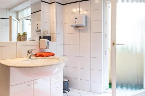 a white bathroom with a sink and a mirror at Ruben's Apartments in Stuttgart