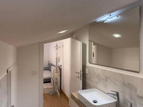 a bathroom with a sink and a mirror and a bed at Blu Celeste in Porto Santo Stefano