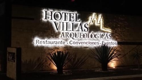 a sign on the side of a building with a hotel villeas advertisement at Villas Arqueologicas Cholula in Cholula
