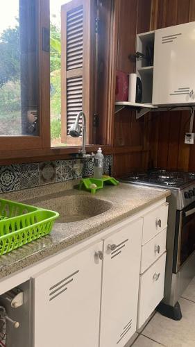 a kitchen counter with a sink and a stove at SíTIO DO LILI- uma experiência em meio à natureza in Marques de Sousa