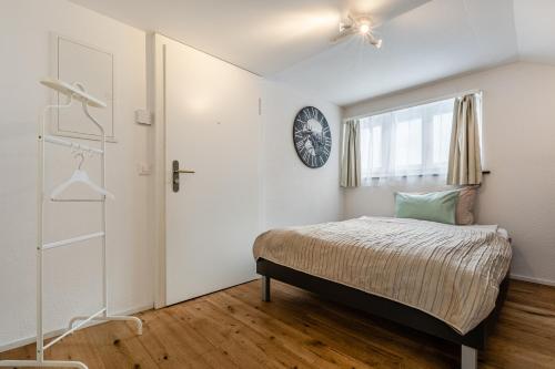 a bedroom with a bed and a clock on the wall at Apartments Sank Georgenstrasse in St. Gallen