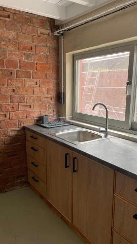 a kitchen with a sink and a brick wall at Villa Hermes, Spacious Getaway in Mytilene in Mytilene