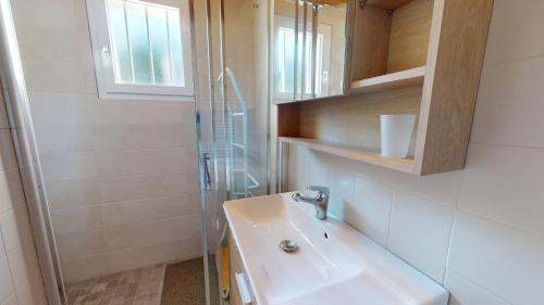 une salle de bain avec un lavabo et une douche dans l'établissement Villa l'Atlantique, à Saint-Hilaire-de-Riez