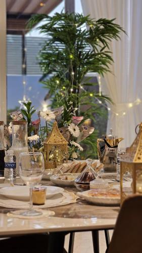 a table with plates of food and glasses on it at July Chalet with Heated Pool in Nizwa