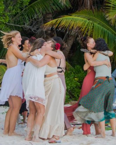 a group of women hugging each other on the beach at Namasthe Ayurveda and Yoga Retreat Cochin in Nedumbassery