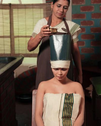 a woman getting her hair cut by a man at Namasthe Ayurveda and Yoga Retreat Cochin in Nedumbassery