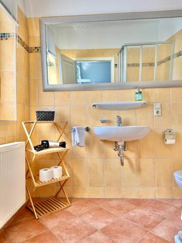 a bathroom with a sink and a mirror at Helles Ferienhaus super zentral mit gratis Stellplätzen N162 in Oldenburg
